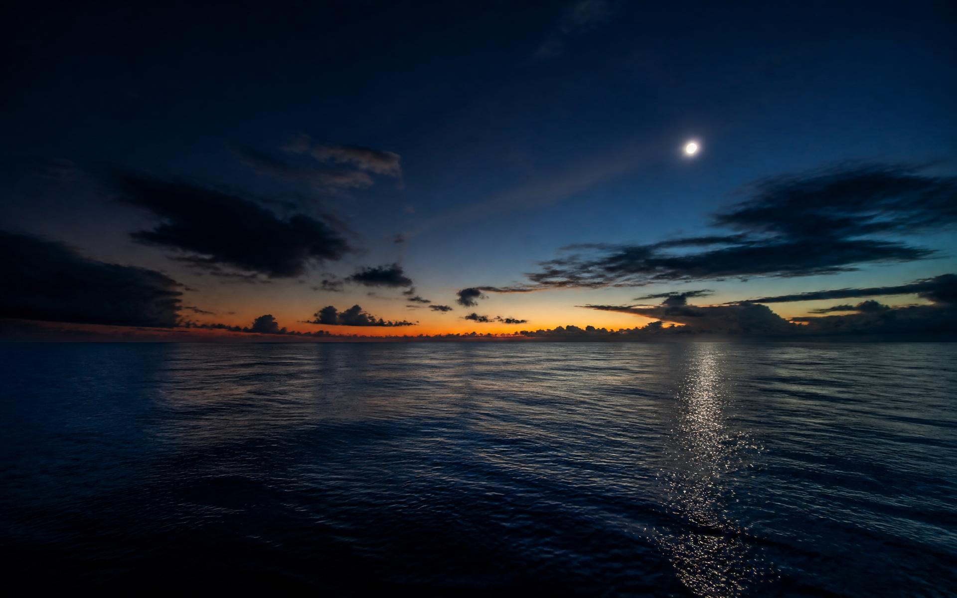Calm ocean at blue hour with the last light meeting deep blue water